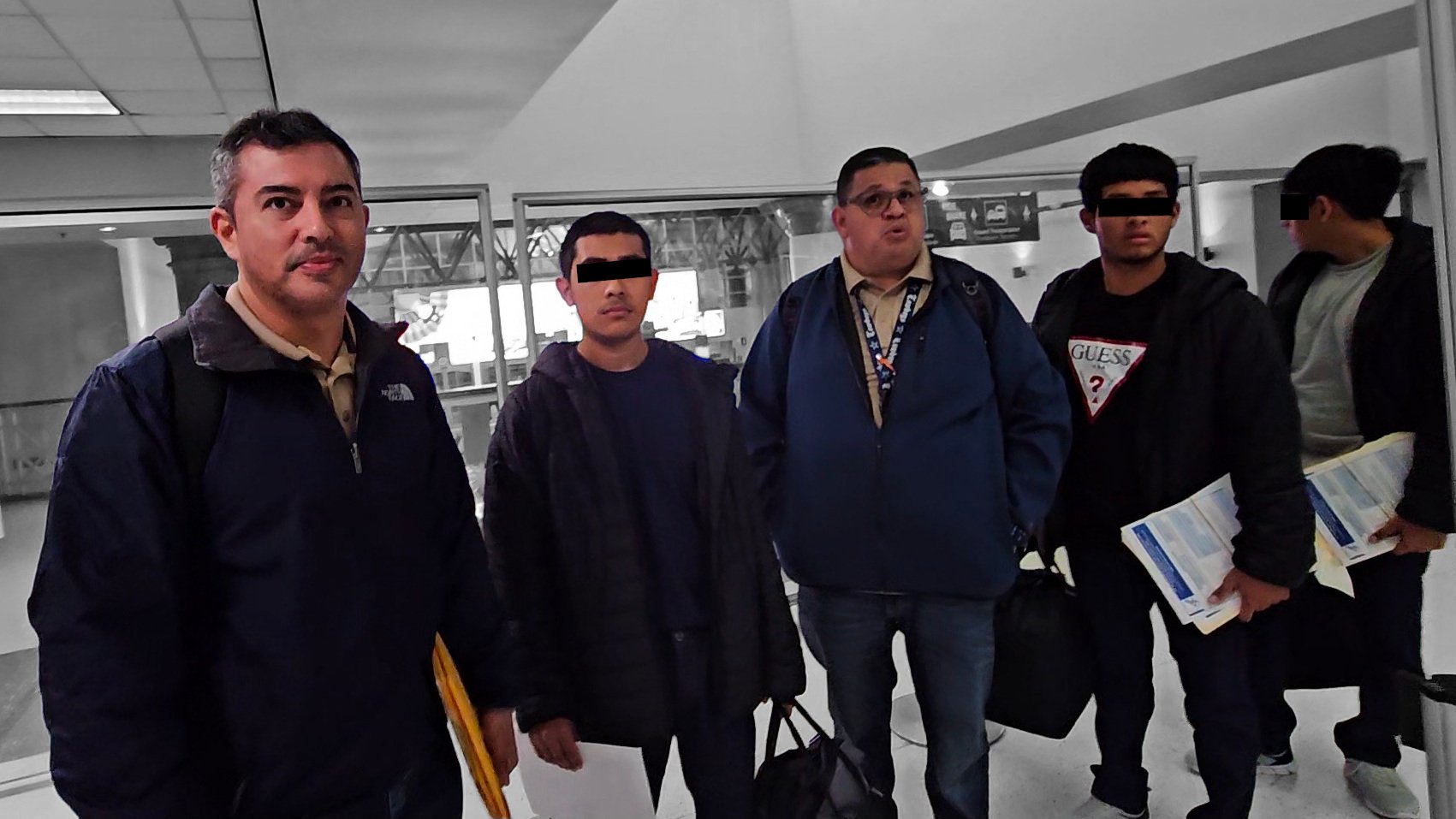 A photo of contractors moving minors through Harlingen airport at 3 a.m.