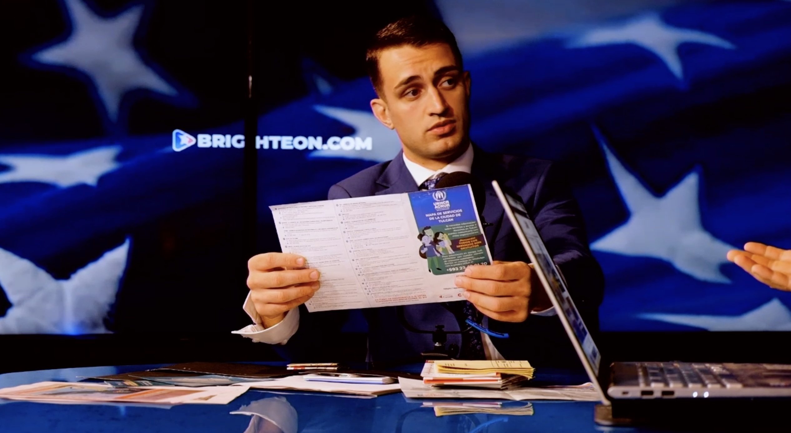 Anthony Rubin holding a UNHCR map while being interviewed by Mike Adams